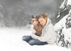 Dog and Girl Cuddling in Snow